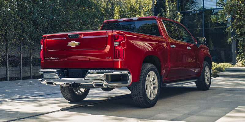 Red Chevrolet Silverado LTZ parked in a paved driveway.